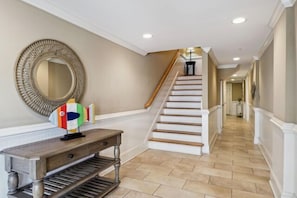 This is the ground floor entrance with elevator down the hall on left. On right is door to garage with a plethora of beach stuff & ping pong table.