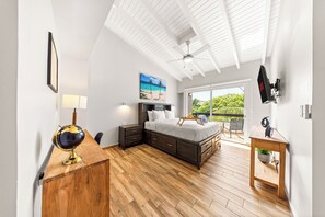 Spacious bedroom with a king-size bed, wood floors, and a balcony with views.