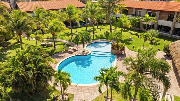Tropical pool oasis with sun loungers, clear waters, and a chic cabana.