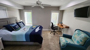 Bedroom with electric standing desk and basic office supplies for remote working