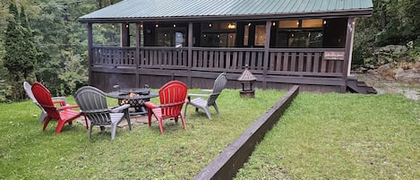 Spacious front deck is relaxing on sunny or rainy days. Bonfire is also a grill!