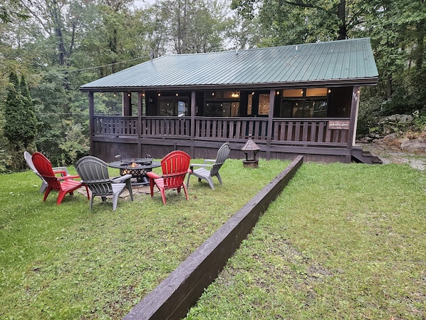 Spacious front deck is relaxing on sunny or rainy days. Bonfire is also a grill!