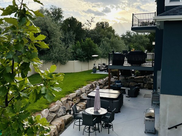 Outdoor private patio with hot tub, fire pit, and dining