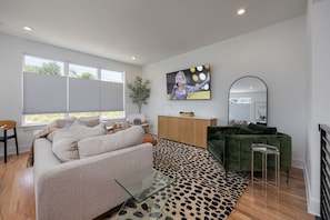 2nd Floor: Inviting and trendy living space featuring designer furnishings and decor offering a pull-out sofa and a Smart TV for entertainment.