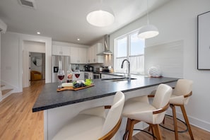 2nd Floor: Fully equipped kitchen boasting stainless steel appliances and stocked with all culinary essentials.