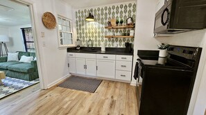 Kitchen is fully stocked with sleek black granite counters and keurig