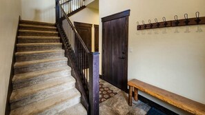 An entryway with coat hooks and a bench greets you at the front door providing a convenient spot to unload your outdoor gear.