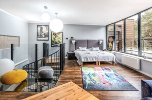 A spacious bedroom with a large bed and floor-to-ceiling windows. Close to forests, the beach, and Lake Resko.