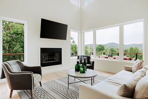Unwind fireside with a view. This stylish living space offers mountain scenery and cozy comfort in one.