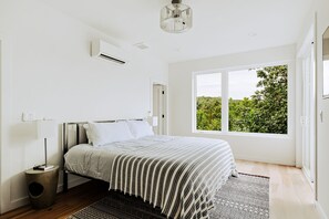 Wake up to trees and tranquility. This serene bedroom offers comfort, simplicity, and views to match.