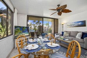 The living room features a queen-size sleeper sofa, flat screen TV, window AC, and a dining area good for 4!