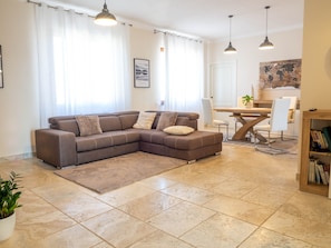 Living room with large sofa bed and dining/working table and smart tv.