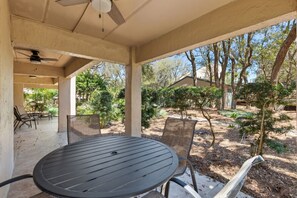 Large Tiled Private Patio with an Outdoor Dining Table, a Lounge Area, and Another Small Seating Area