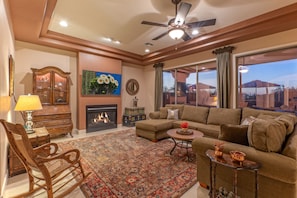 Wow! A formal living room with comfy seating, TV, gas fireplace and outdoor views.