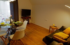 Ferienwohnung mit Balkon-Wohnküche mit Couch und TV