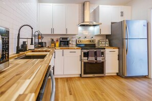 Cook like a pro in this fully stocked kitchen with stainless steel appliances, butcher block counters, and modern amenities.