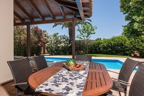 Savor your meals by the pool, embraced by the cool shade, creating a delightful and relaxing dining experience in this tranquil oasis.