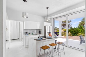 Graceful Kitchen of the vacation house in Santa Cruz Aruba - Fully equipped - Elegant and coordinated color palette for a cohesive look - Open concept connecting the kitchen to the dining and living area - Meal Bar and Bar chairs