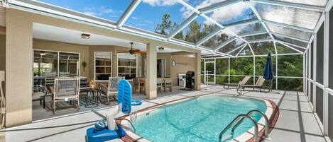Heated pool in private back lanai surrounded by palm trees!